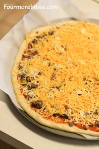 Top the bacon cheeseburger pizza with cheese