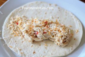 Assembling creamy chicken enchiladas