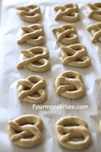 Homemade soft pretzels formed and sitting on the counter to rise.