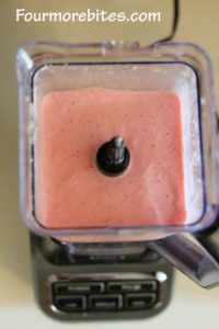 Blender with strawberry yogurt popsicle ingredients blended up 