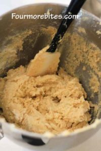 Lime sugar cookie dough, in a stand mixer bowl, ready to be rolled into balls