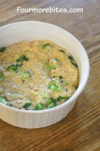 Cheesy rice and broccoli casserole poured into a white corningware dish sitting on an oak table