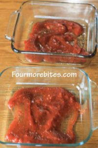 1/2 cup marinara sauce in the bottom of two 8x8 glass pans 