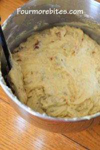 Banana nut muffin batter in a stainless steel bowl that is sitting on a wooden table