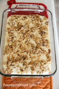 Cream cheese mixture of lemon pecan bars topped with pecan topping.