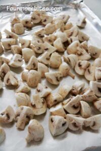 Mushrooms on a foil lined cookie sheet ready to go in the oven